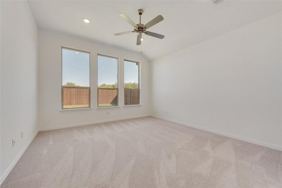 Spare room with ceiling fan, light carpet, and lofted ceiling