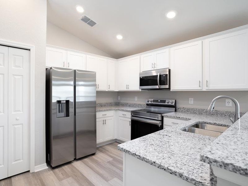 Your bright and open kitchen has ample cabinet and counter space, along with a pantry - Aurora home plan by Highland Homes