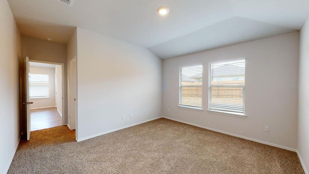 Spacious room featuring neutral carpet flooring, light-colored walls, and two large windows with blinds