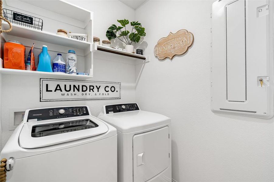The laundry area features white walls, upper shelving, and a top-loading washing machine