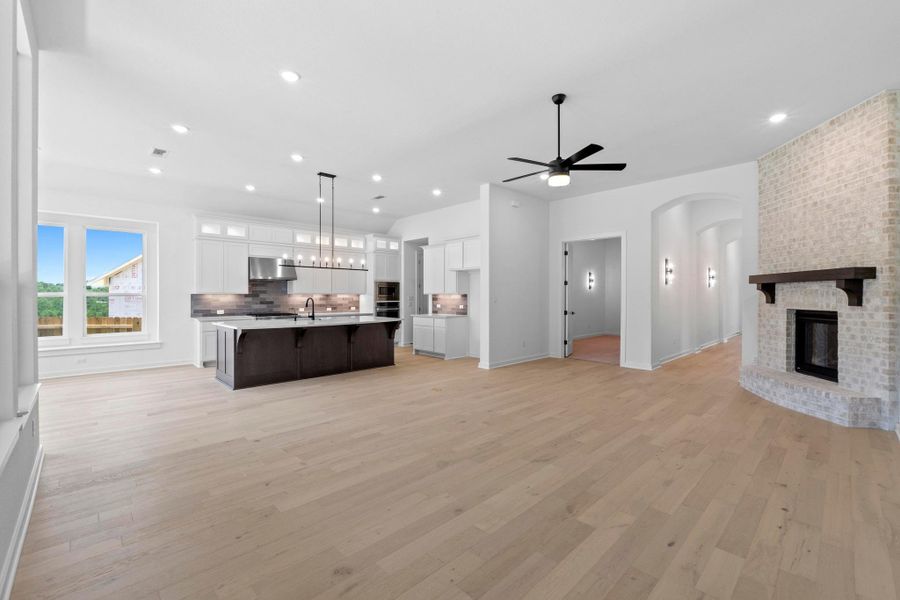 Kitchen featuring open floor plan, light countertops, white cabinets, backsplash, and recessed lighting