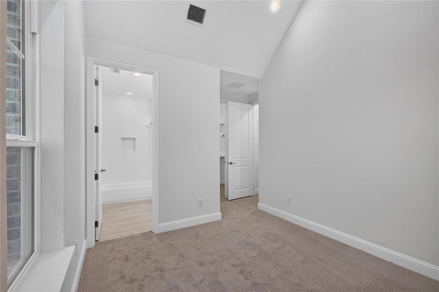 Carpeted room with vaulted ceiling and recessed lighting Carpeted room with vaulted ceiling and recessed lighting