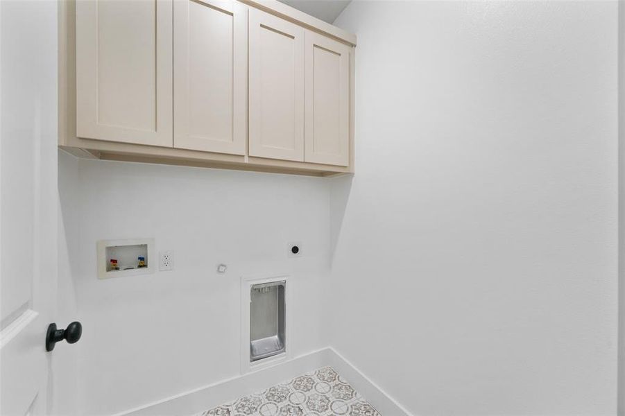 Laundry room with patterned tile flooring and overhead cabinetry featuring shaker-style doors Laundry room with patterned tile flooring and overhead cabinetry featuring shaker-style doors