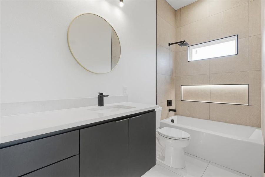 Modern bathroom featuring a single vanity with dark cabinetry and a light-toned countertop Modern bathroom featuring a single vanity with dark cabinetry and a light-toned countertop