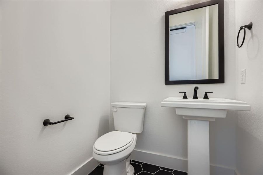 Bathroom with baseboards and dark tile patterned flooring