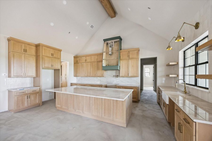 Another view of kitchen.  Farmhouse sink with windows above and opening shelving on either side.