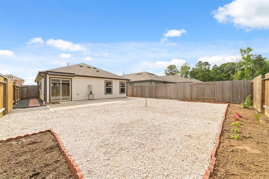 Expansive backyard with low-maintenance gravel and defined garden beds, ready for your personal touch.