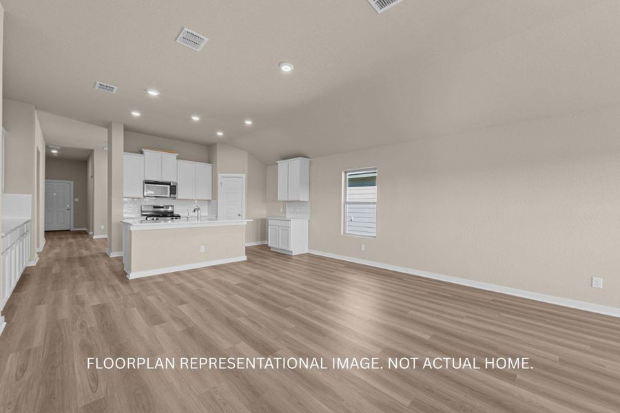 An inviting open-concept layout connects the kitchen and living spaces, featuring resilient wood-look flooring and a functional breakfast bar.