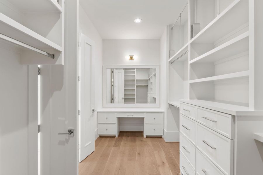 Her oversized closet with a dedicated dressing area with a built-in vanity and mirror adds an extra layer of functionality, creating a boutique-style closet experience.