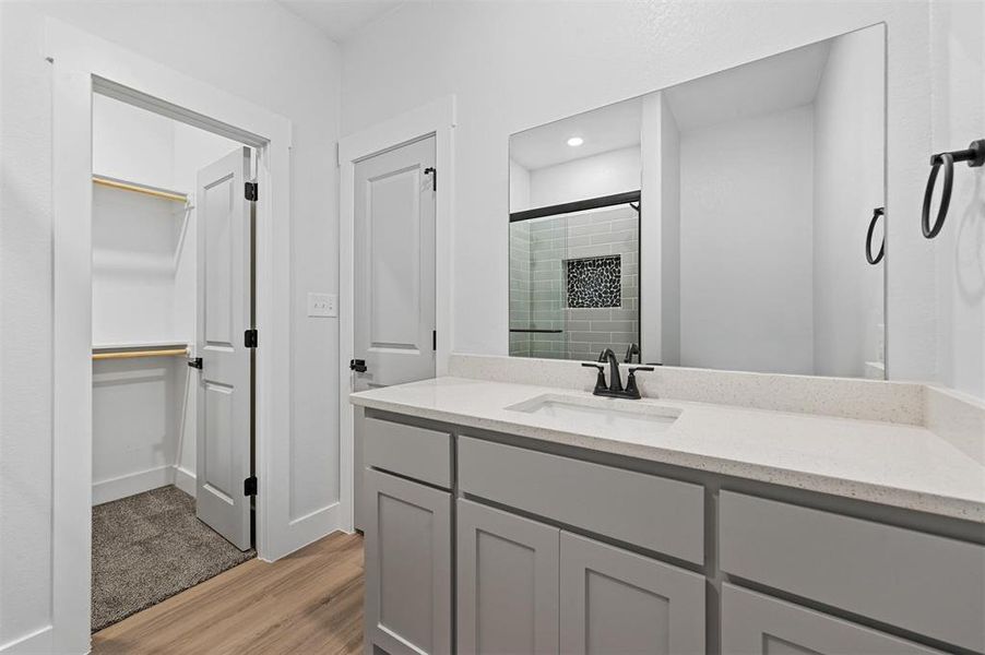 Bathroom with vanity, hardwood / wood-style flooring, and walk in shower