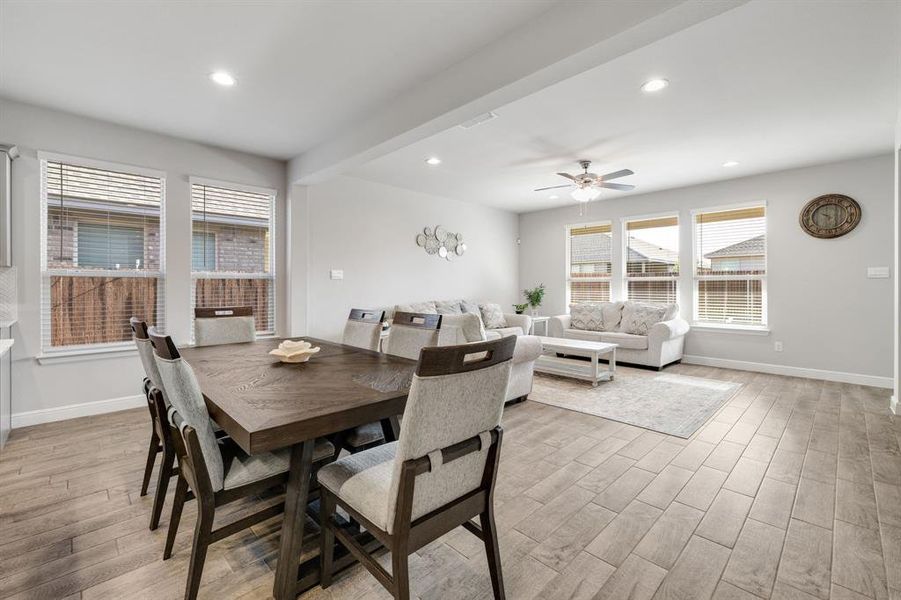 Dining space with recessed lighting, a ceiling fan, light wood finished floors, and beam ceiling