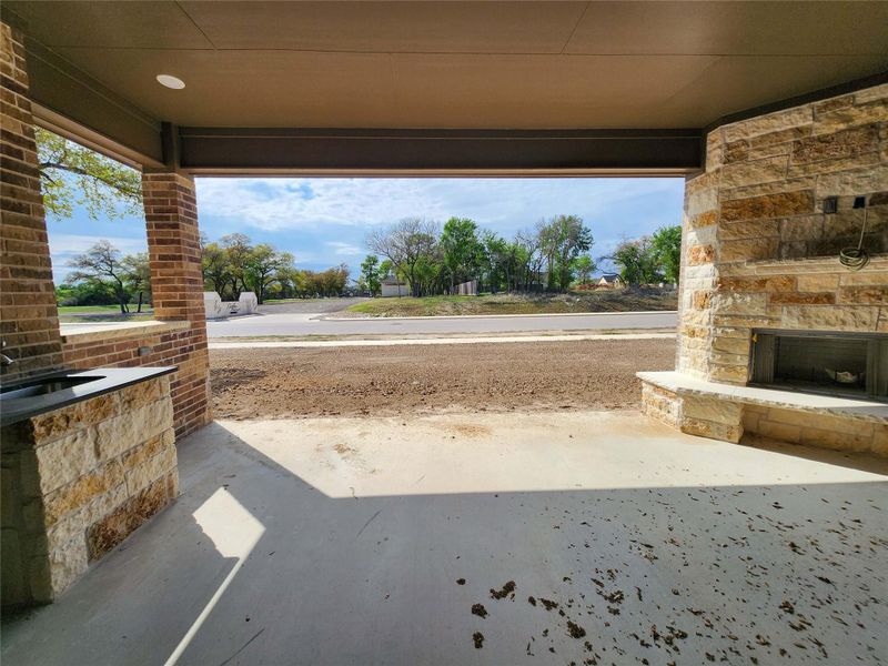 View of patio / terrace featuring an outdoor stone fireplace