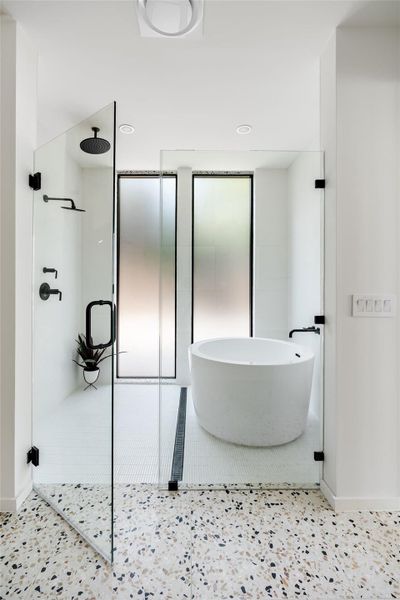 Full bath featuring a walk in shower, a freestanding tub, and recessed lighting