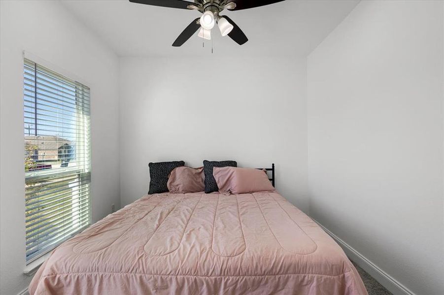 Bedroom with baseboards and a ceiling fan Bedroom with baseboards and a ceiling fan