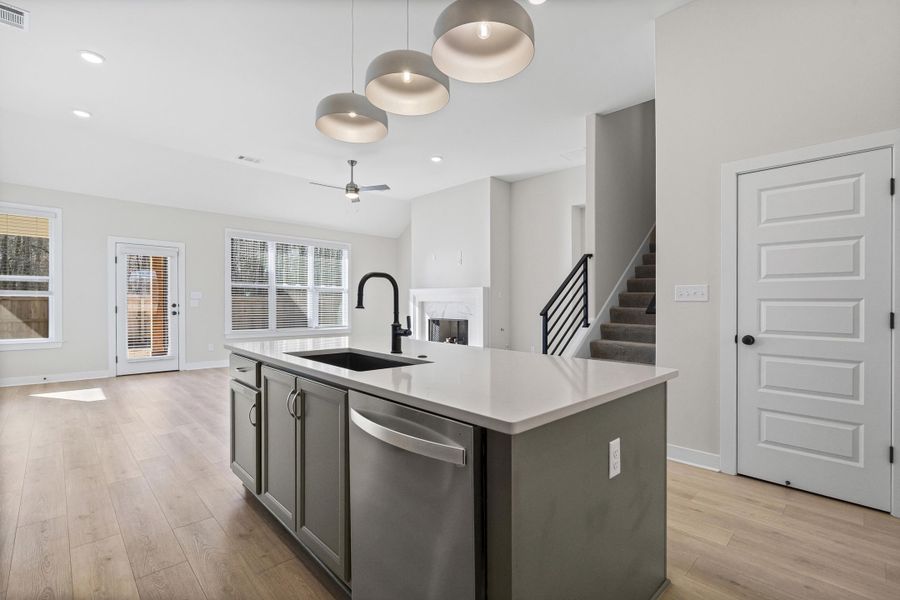 Kitchen with dishwasher, a kitchen island with sink, decorative light fixtures, light wood-style floors, and recessed lighting Kitchen with dishwasher, a kitchen island with sink, decorative light fixtures, light wood-style floors, and recessed lighting