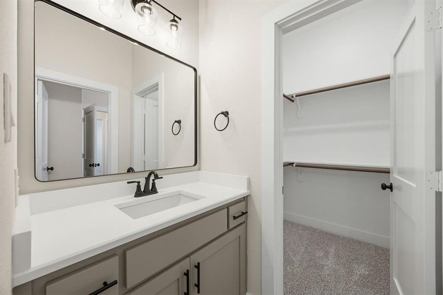 Bathroom vanity with a rectangular undermount sink, quartz countertop, and matte black faucet