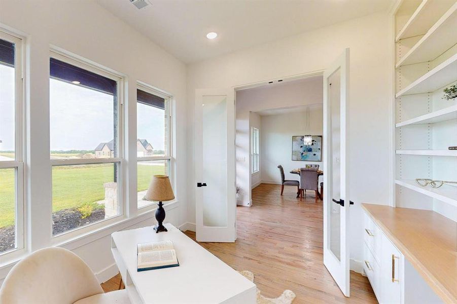 Office with light hardwood / wood-style floors and french doors