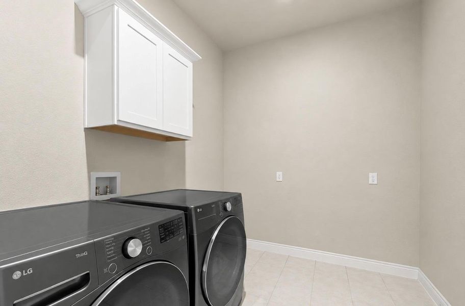 Functional laundry space featuring modern appliances and convenient overhead cabinetry. Functional laundry space featuring modern appliances and convenient overhead cabinetry.