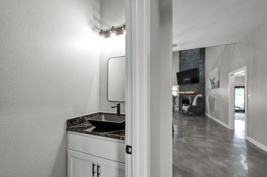The bathroom has a sleek black countertop and vessel sink, adding a touch of elegance.