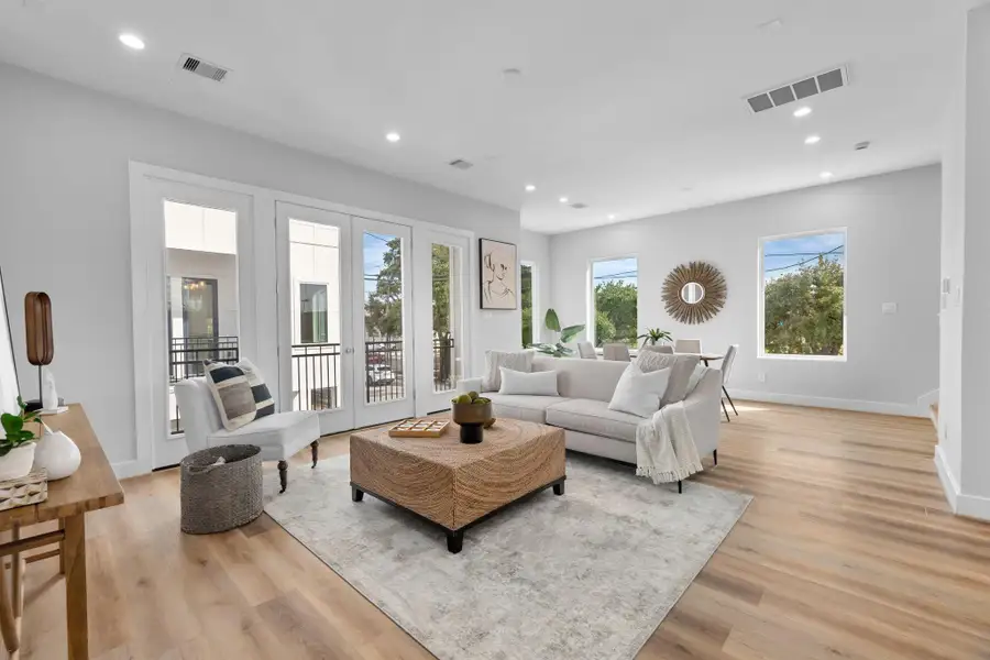 Bright and airy living space featuring oversized windows and direct access to a private balcony, creating a perfect indoor-outdoor living experience.