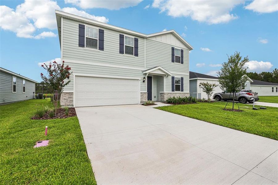 Front exterior of a new home in Flagler Village - Signature Series, Palm Coast, FL, highlighting curb appeal (Image 1). Front exterior of a new home in Flagler Village - Signature Series, Palm Coast, FL, highlighting curb appeal (Image 1).