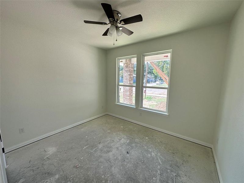 Empty room with a textured ceiling and ceiling fan