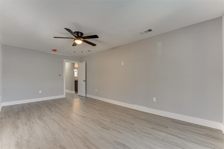 Unfurnished room with ceiling fan and light wood-type flooring