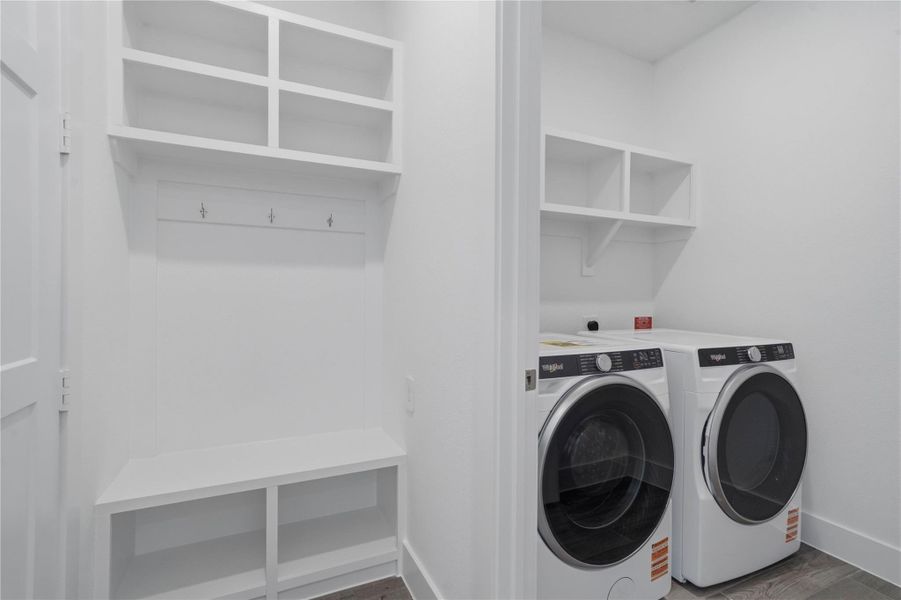 Convenient utility space showcasing Whirlpool front-load washer and dryer appliance set with multi-level shelving above to store your laundry needs. Convenient utility space showcasing Whirlpool front-load washer and dryer appliance set with multi-level shelving above to store your laundry needs.