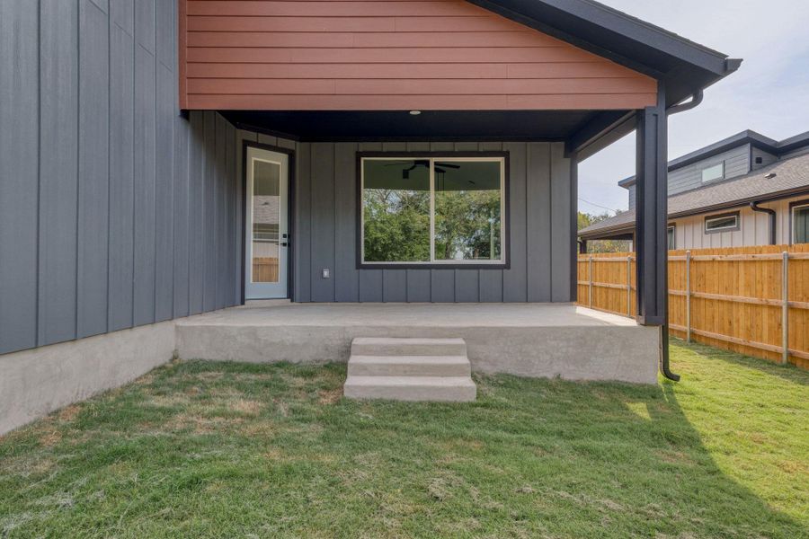 Property entrance with board and batten siding, a patio area, and a ceiling fan Property entrance with board and batten siding, a patio area, and a ceiling fan