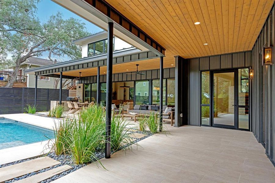 Inside the front gate, a wide walkway leads to the front door and outdoor living and dining areas.