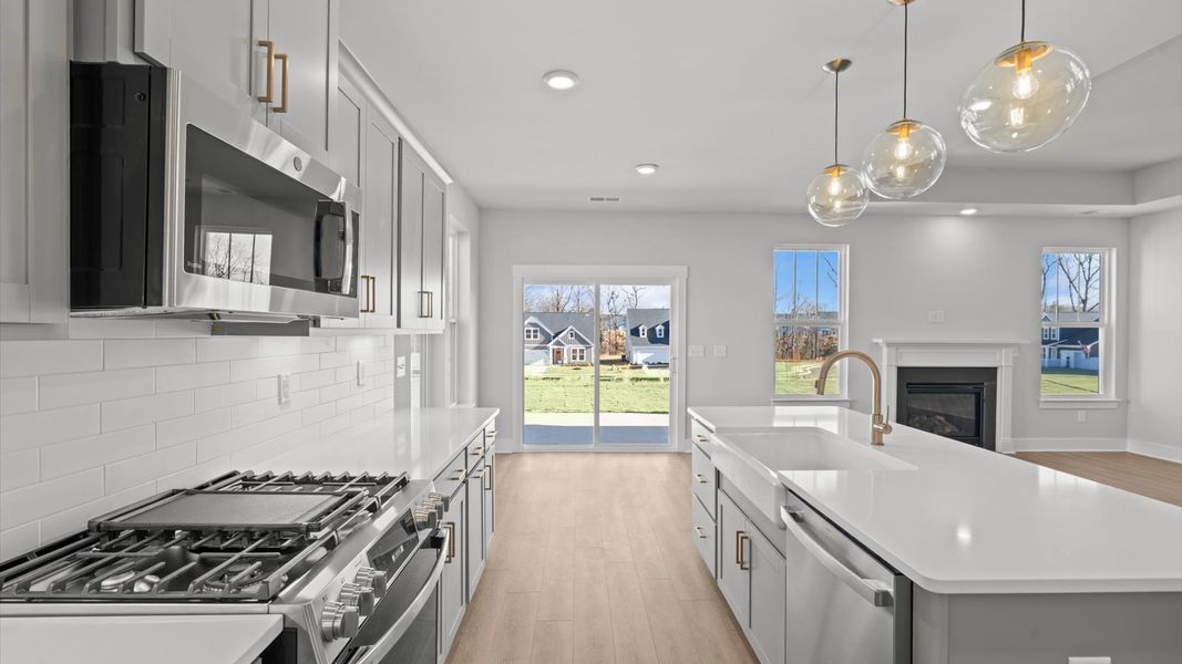 Tasteful design meets functional luxury in this kitchen with a 7-foot island and modern pendant lighting