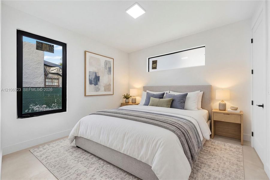 Neutral interior space featuring high-contrast black-framed windows, a horizontal transom window, recessed ceiling lighting, and hard-surface flooring Neutral interior space featuring high-contrast black-framed windows, a horizontal transom window, recessed ceiling lighting, and hard-surface flooring