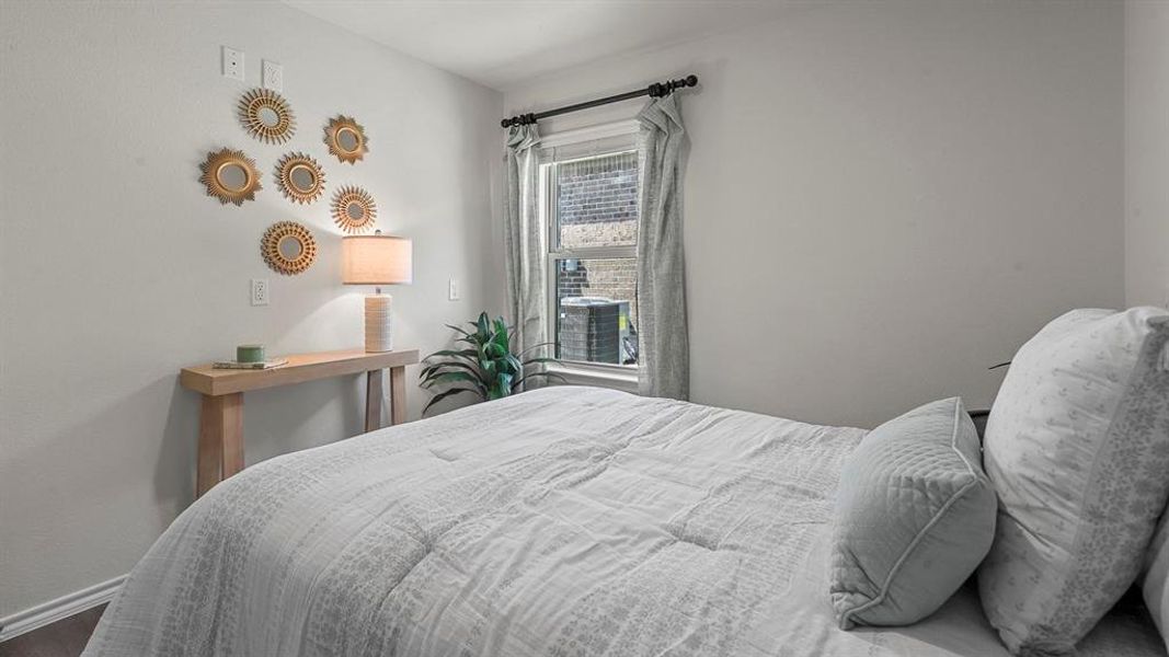 The bedroom features light-colored walls and a window with curtains