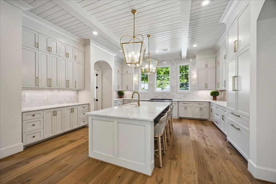 Another view of this fabulous kitchen highlights the expansive island with seating, gorgeous Zellige tile backsplash and extensive custom cabinetry throughout. Thermador 48” gas range, built-in refrigerator, dishwasher and microwave are paired with marble surfaces and thoughtfully designed storage for a polished, functional space. We love the gorgeous hardware and the view through the windows of the lovely street! Looking for light and bright---you have found it!