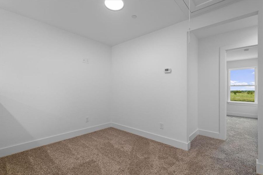 Carpeted spare room with baseboards and attic access Carpeted spare room with baseboards and attic access