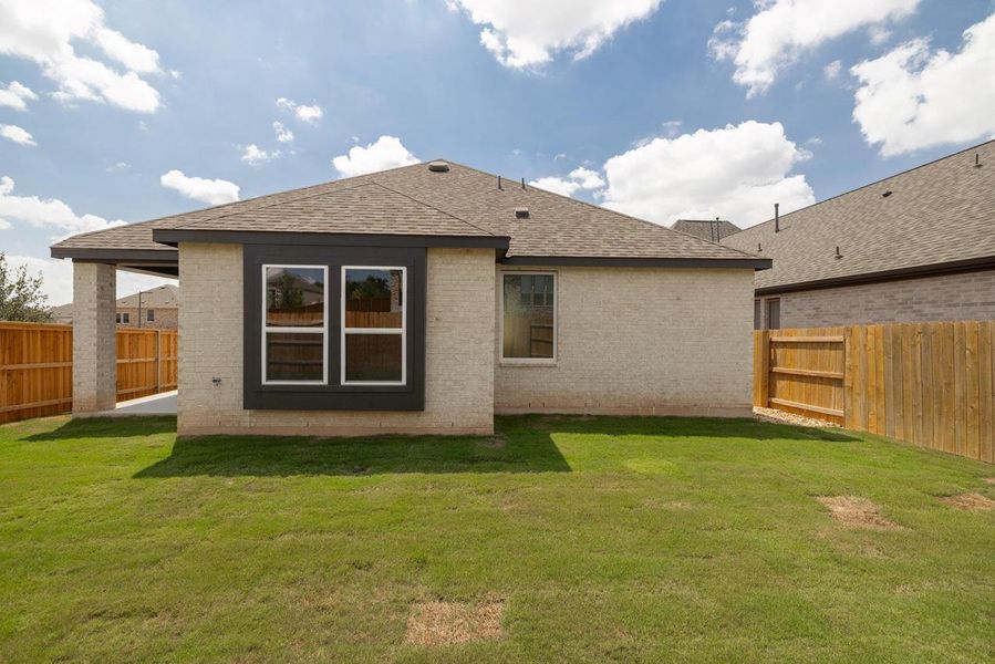 Back of property with brick siding, a fenced backyard, roof with shingles, and a patio Back of property with brick siding, a fenced backyard, roof with shingles, and a patio