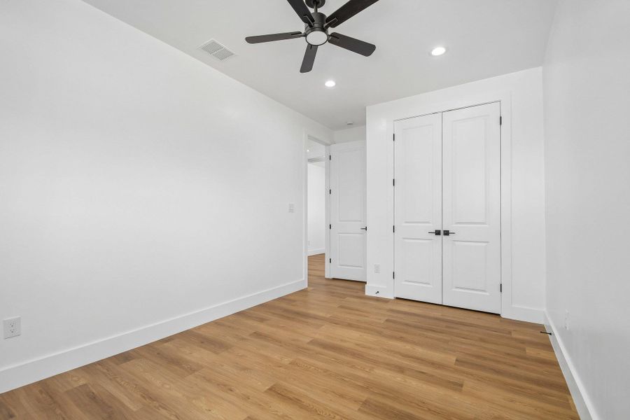 Crisp white walls complement the warm wood flooring under a clean minimalist ceiling. Crisp white walls complement the warm wood flooring under a clean minimalist ceiling.