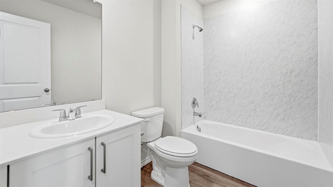 Bathroom featuring vanity, light wood-type flooring, and bathtub / shower combination
