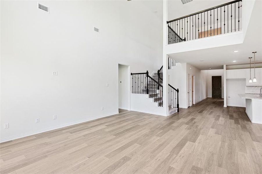 Unfurnished living room with a high ceiling and light hardwood / wood-style flooring