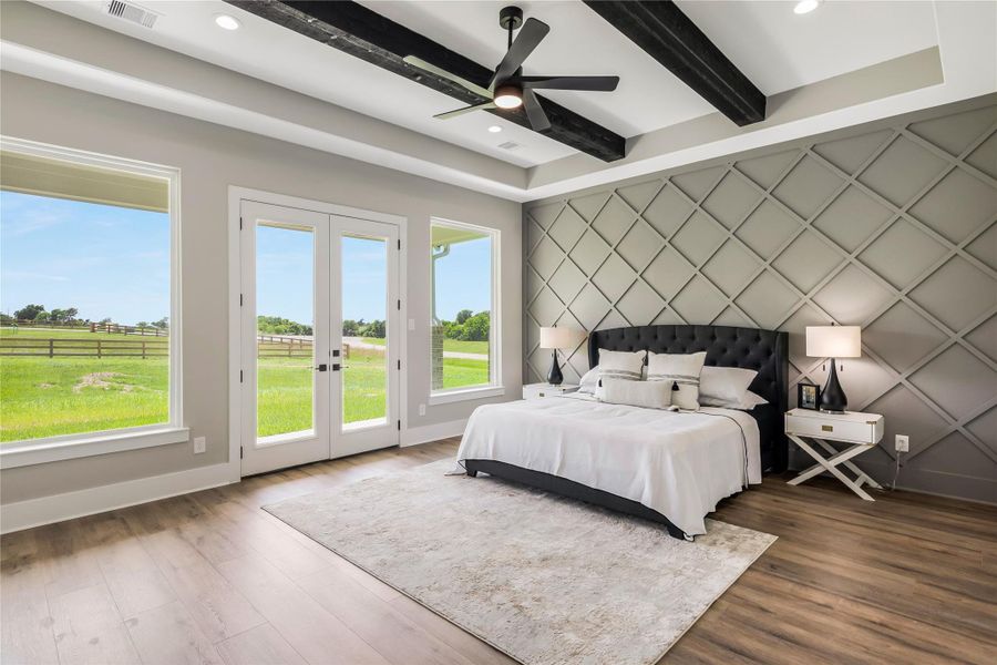 Primary bedroom features a modern design with a statement accent wall, large windows for natural light, and elegant flooring. French doors open to a scenic view, while exposed ceiling beams add a touch of rustic charm. Primary bedroom features a modern design with a statement accent wall, large windows for natural light, and elegant flooring. French doors open to a scenic view, while exposed ceiling beams add a touch of rustic charm.