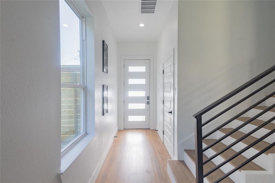 Foyer entrance featuring stairway and light wood-type flooring Foyer entrance featuring stairway and light wood-type flooring