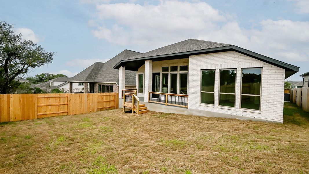 Back of house featuring brick siding and roof with shingles