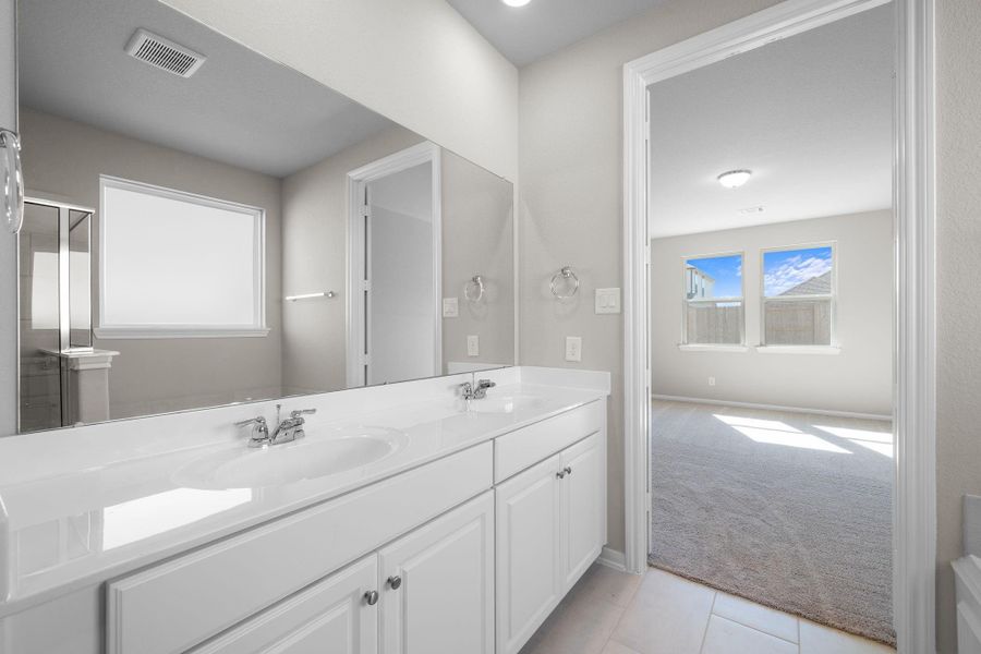 The en-suite bathroom offers a spa-like atmosphere with its elegant design, high end finishes, and tasteful lighting, creating a retreat within your own home.