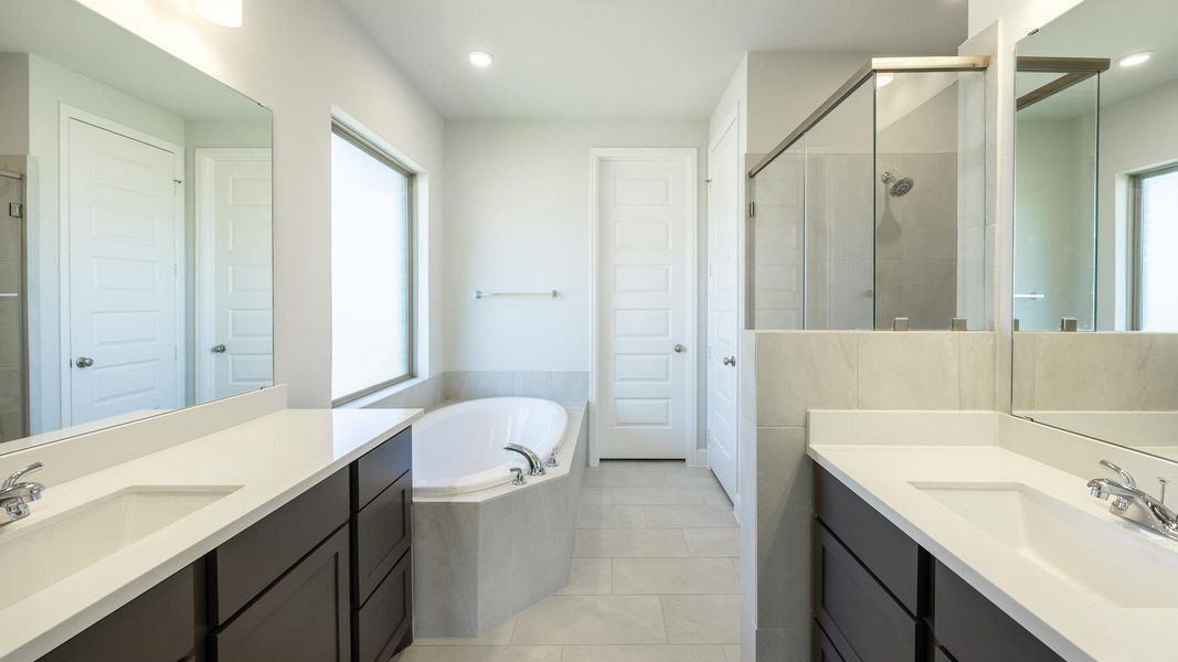 Bathroom featuring a sink, a wealth of natural light, a stall shower, and a bath Bathroom featuring a sink, a wealth of natural light, a stall shower, and a bath