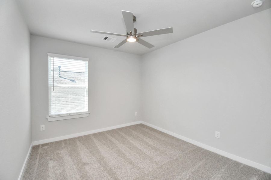 Secondary bedroom features plush carpeting, large windows that let in plenty of natural light, bright paint, and spacious closets. Sample photo of completed home with similar floor plan. Actual colors and selections may vary. Secondary bedroom features plush carpeting, large windows that let in plenty of natural light, bright paint, and spacious closets. Sample photo of completed home with similar floor plan. Actual colors and selections may vary.
