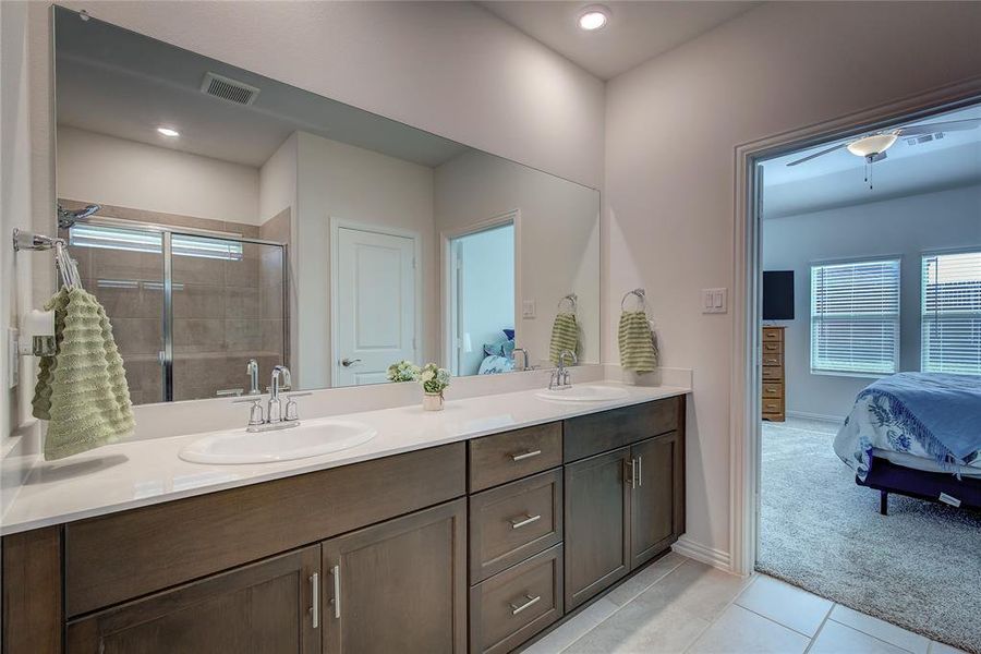 Bathroom with vanity, tile patterned floors, walk in shower, and ceiling fan