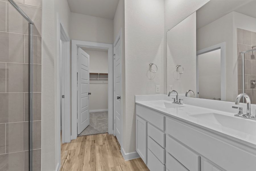 A bathroom with a sink and a shower unit. A bathroom with a sink and a shower unit.