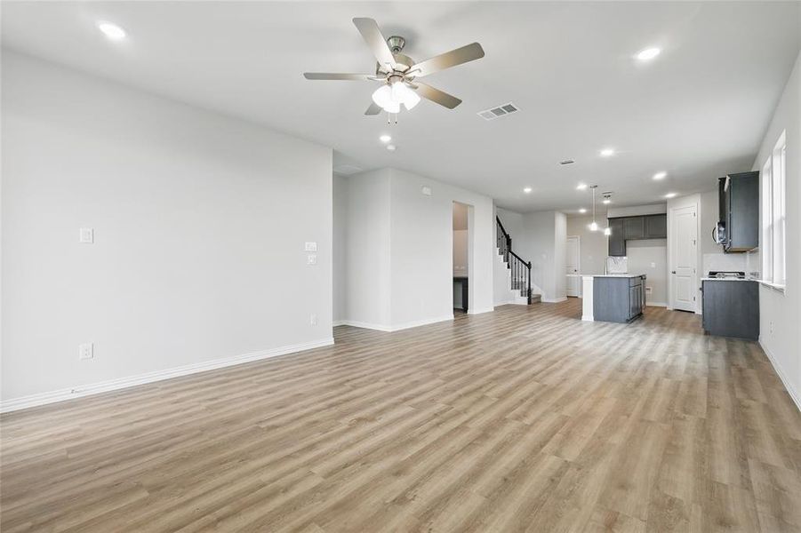 Unfurnished living room featuring light wood-type flooring, stairway, recessed lighting, and ceiling fan Unfurnished living room featuring light wood-type flooring, stairway, recessed lighting, and ceiling fan