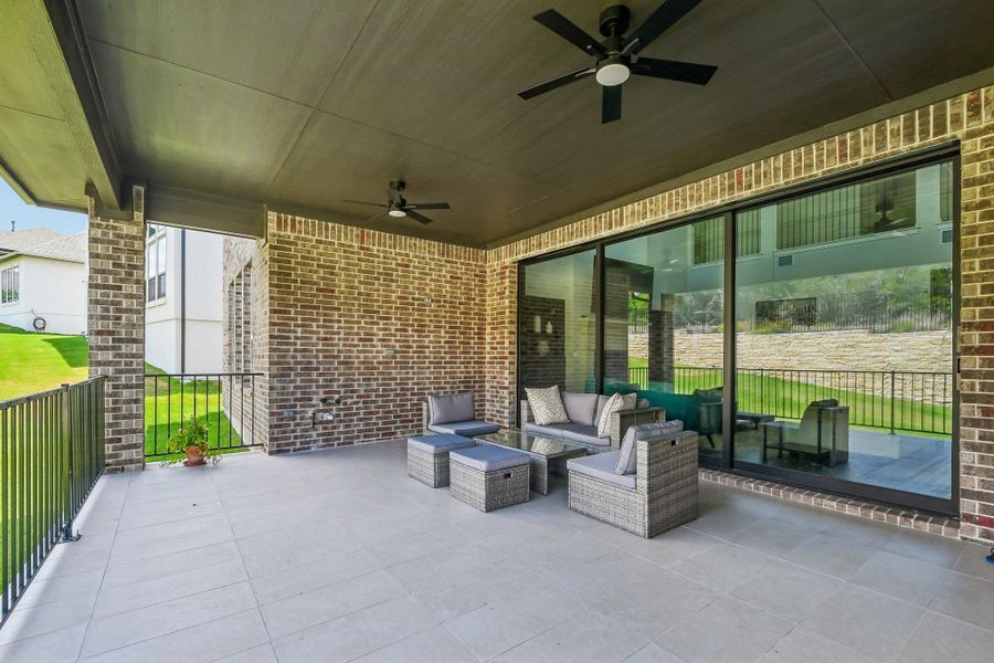 An inviting covered patio featuring robust brick construction and sleek sliding glass doors offers abundant outdoor living space. An inviting covered patio featuring robust brick construction and sleek sliding glass doors offers abundant outdoor living space.