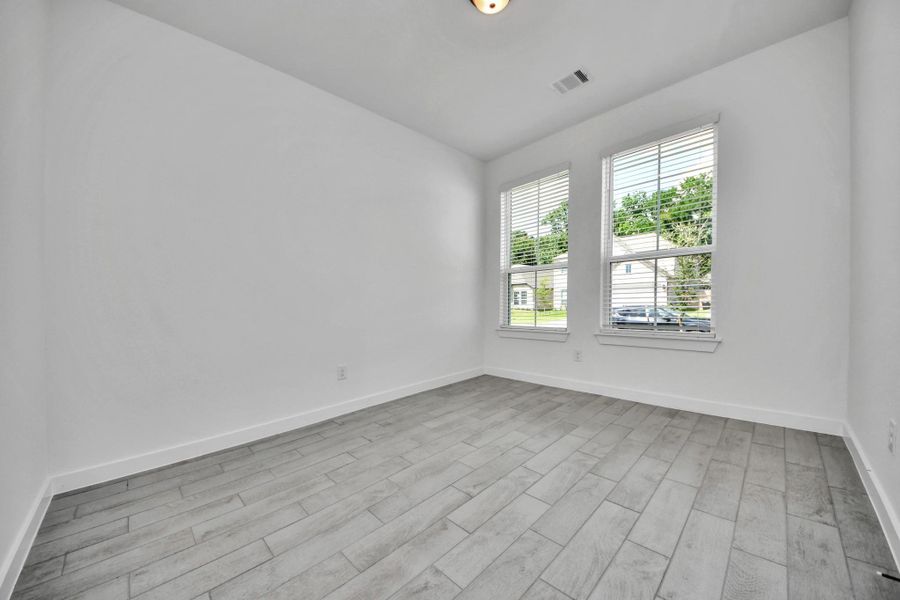 Step into the inviting home office, where elegant tile flooring adds a touch of freshness and comfort to the workspace. Natural light pours through the window, creating an inspiring environment for productivity and focus. Sample photo of completed home with similar floor plan. Actual colors and selections may vary.